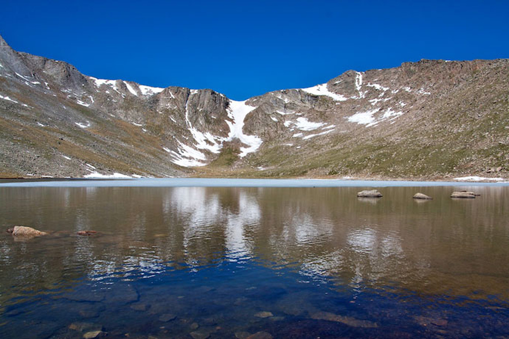 Bjergene spejler sig i det isfri vand ved Summit Lake Bjergene spejler sig i det isfri vand ved Summit Lake