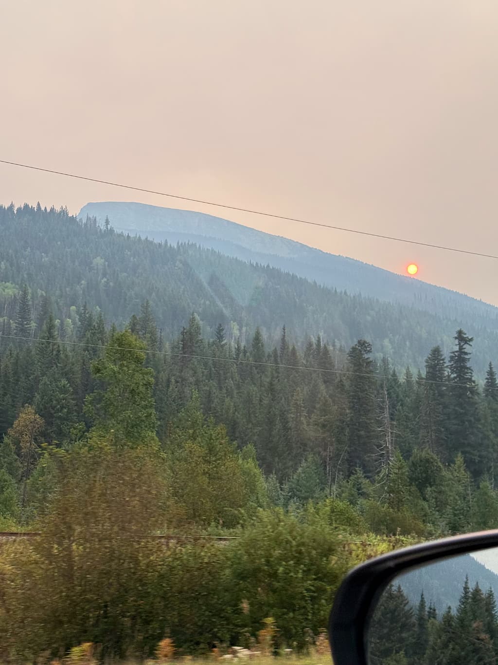 Orange morgensol gennem røg fra skovbrande på køreturen vestpå fra Rearguard Falls